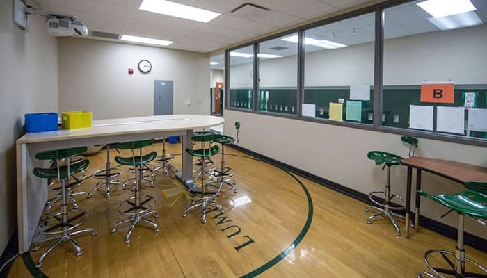 A flexible student / teacher workspace in the Catholic elementary school, Lumen Christi in Mequon, Wisconsin. Furniture allows the room to serve many functions, and glass provides views in and out of the room to increase supervision and safety.