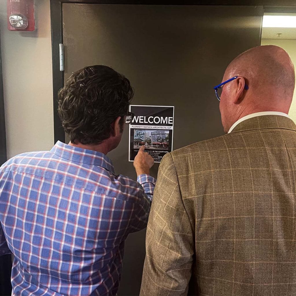 Partner and Architect, John Holz, and Partner and Healthcare Architect, Kevin Broich, read sign for PRA Fl's Open House