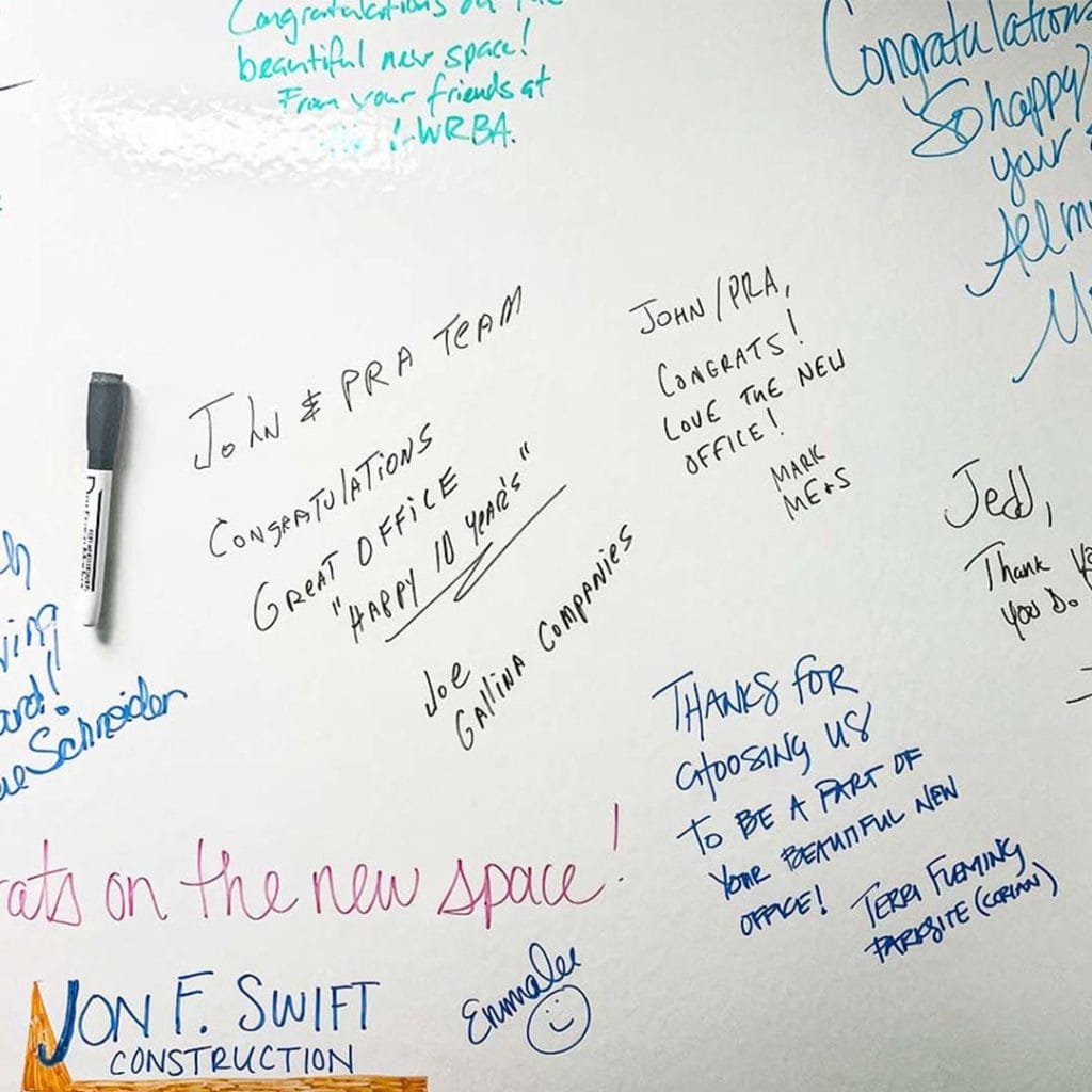 Guests sign white board for PRA's Sarasota office open house