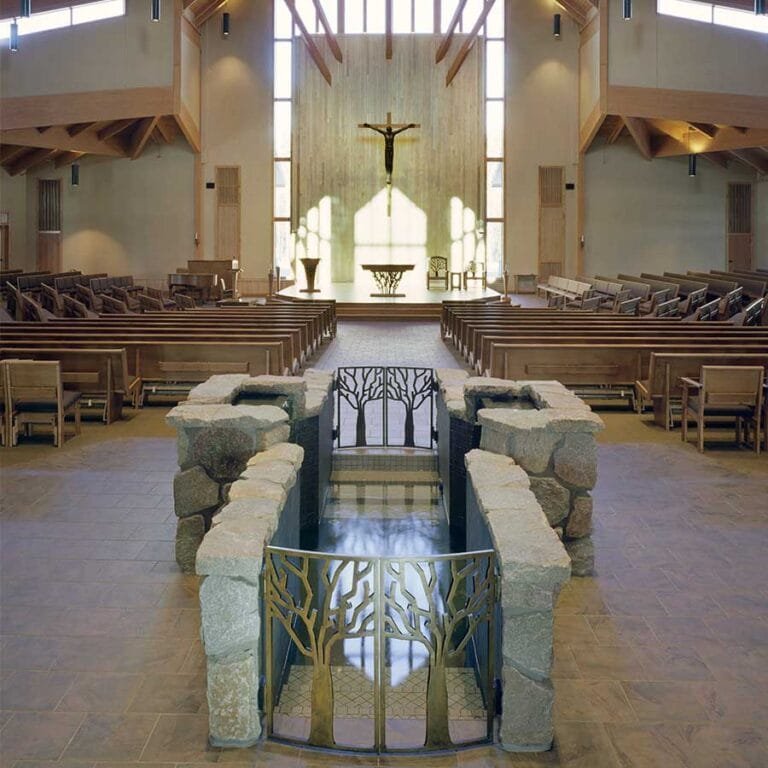 The Holy Family Catholic Church in Woodruff, WI celebrates a sacrament with a Baptismal Font, mixing references to nature and religious symbolism of placing it near the entry of the Sanctuary symbolizing entry into Christianity