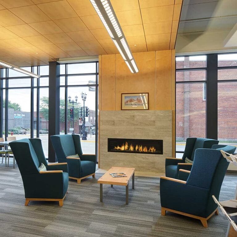 Platteville Public Library Fireplace and Lounge Area. The fireplace features porcelain tile and wood ceiling, creating a focal point and pleasant area to read.