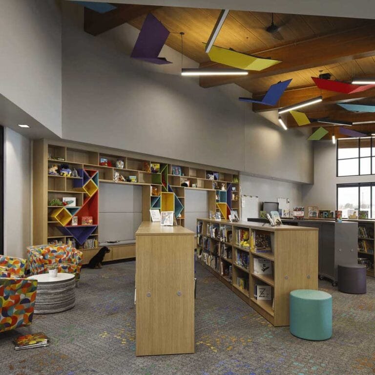 The library features colorful acoustical panels and custom bookshelves with integrated benches
